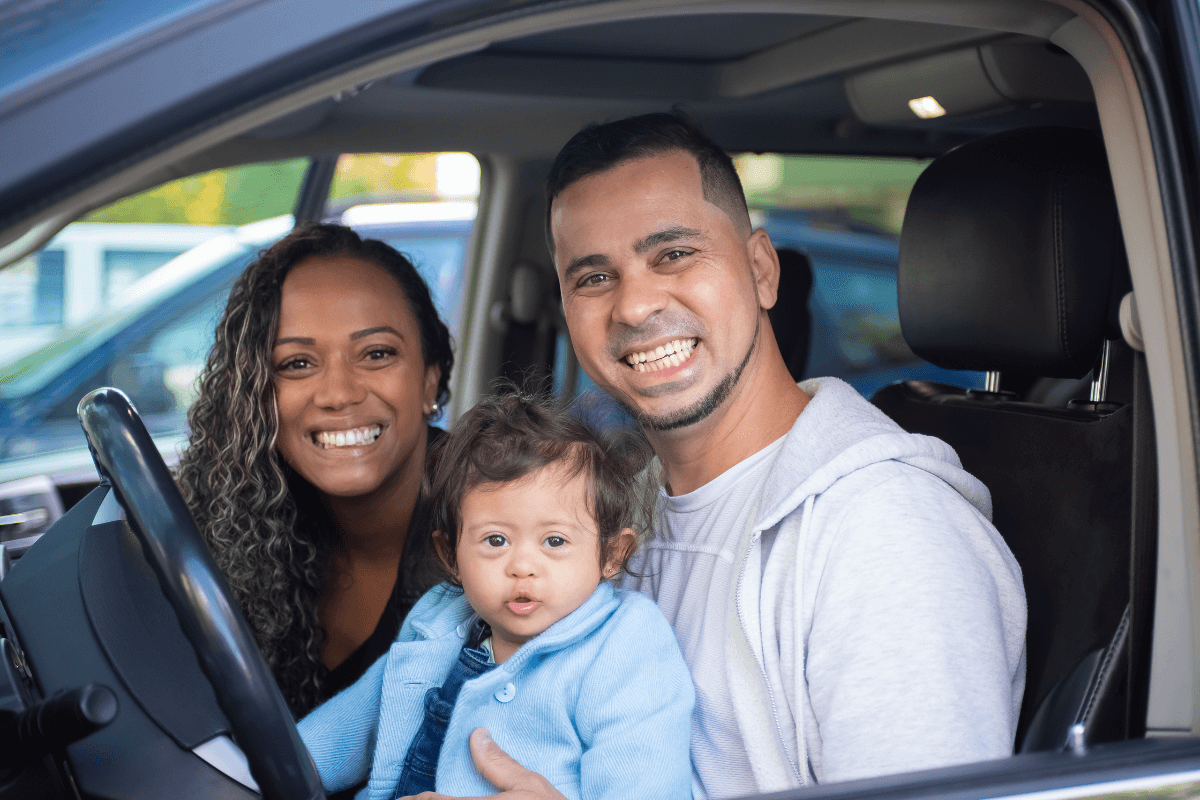 alt=familia feliz e segura dentro do carro.