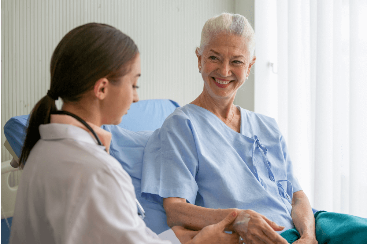 Idosa feliz sendo cuidada por uma profissional da saúde em um hospital